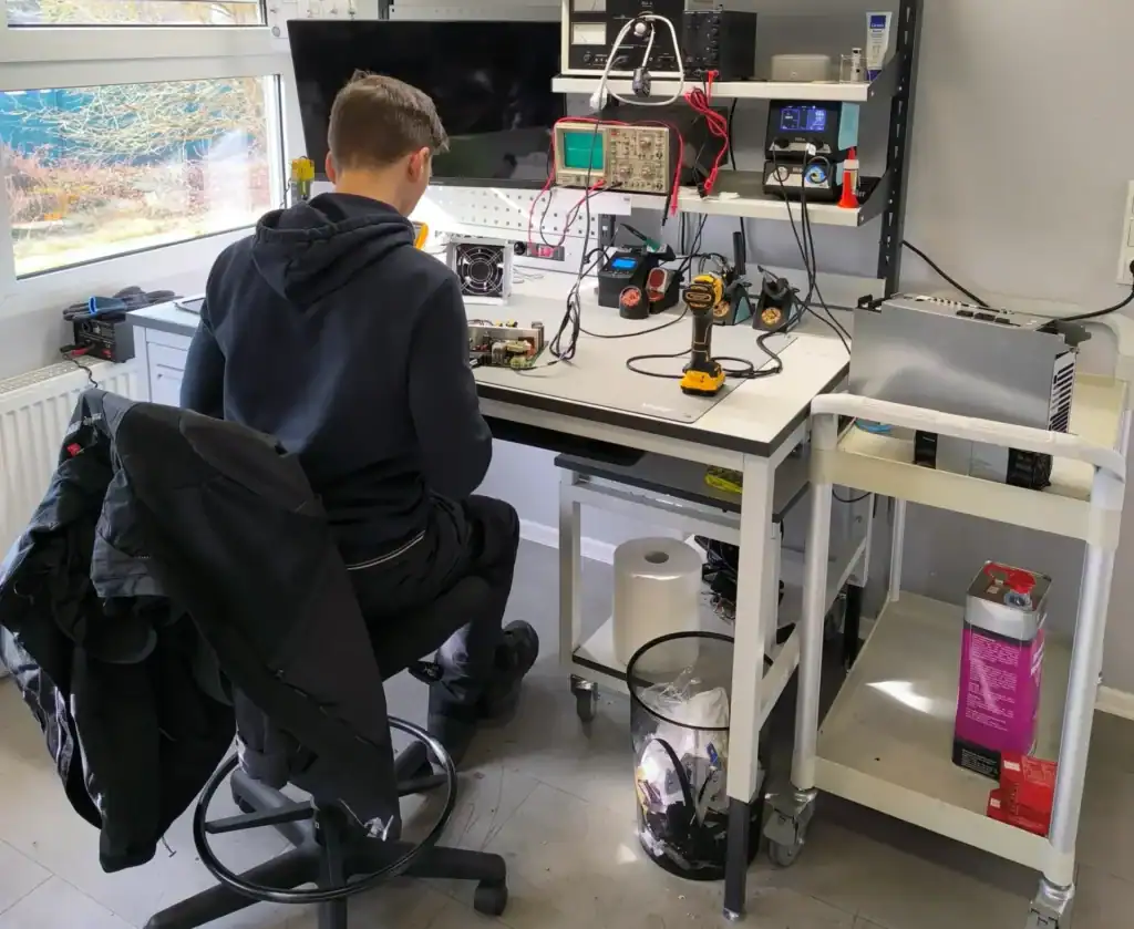 Techniker führt Elektronikreparatur an einer Okuma CNC-Steuerung durch
