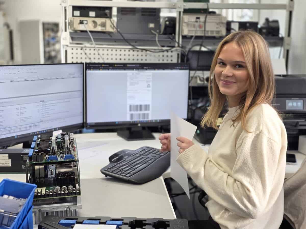 Mitarbeiterin arbeitet an mehreren Monitoren im Bereich CNC-Elektronikservice