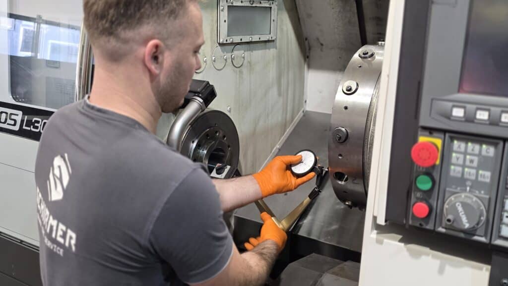 Technician setting up a CNC lathe machine